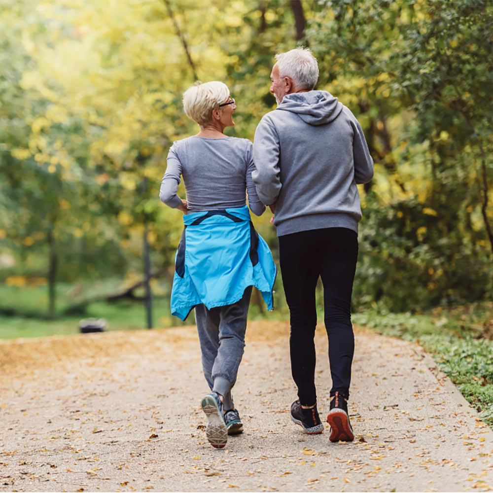 senior couple jogging in park together