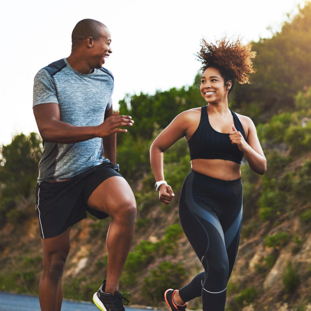 couple running in nature by a mountain training for a race