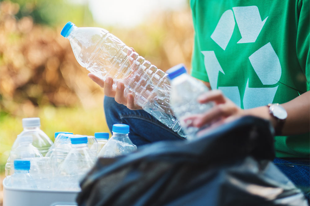 woman recycling empty water bottles