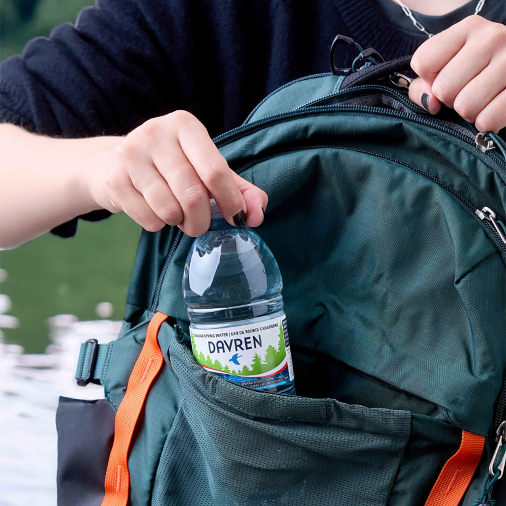 woman hand taking water bottle from backpack